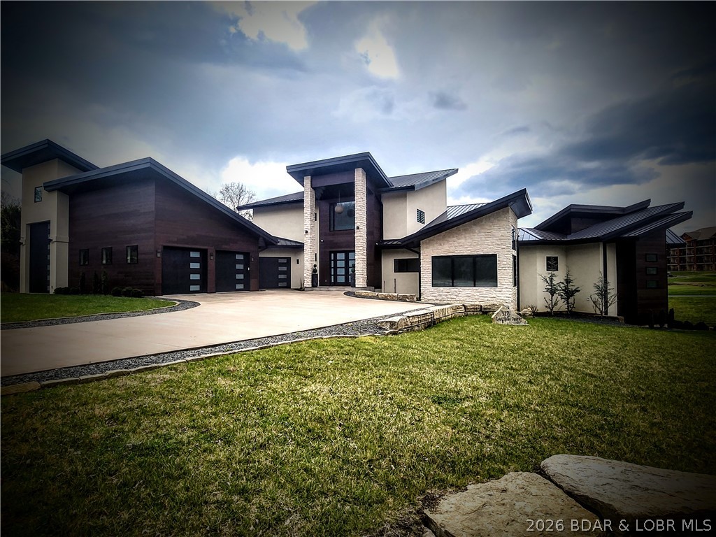 Designed to capture the breathtaking beauty of Lake of the Ozarks, this extraordinary 9,600 sq ft estate in Old Kinderhook defines luxury living and prime investment potential. Panoramic views surround you, while dramatic window walls and sleek glass railings create a seamless connection between sophisticated interiors and stunning outdoor spaces.
The main-level owner’s suite with a private screened-in patio offers a serene retreat, complemented by a chef’s kitchen with premium stainless appliances, an expansive great room, media room, loft, and multiple private guest suites. Thoughtfully designed outdoor living includes an entertainer’s deck and outdoor kitchen—perfect for unforgettable gatherings. Smart home technology and custom finishes elevate every detail.
Enjoy our own private pool, and hot tub—your personal resort. Just a golf cart ride away: the Tom Weiskopf designed Old Kinderhook Golf Course, pools, pickleball, and tennis. Savor the food and the views at The Trophy Room or Hook Cafe.
See not included: 20x50 Boat slip with a 27' Bennington Tritoon w/lift, 3 jet skis w/ lifts & Lakeside outdoor entertaining area.
AND the golf frontage lot next door to expand your venue