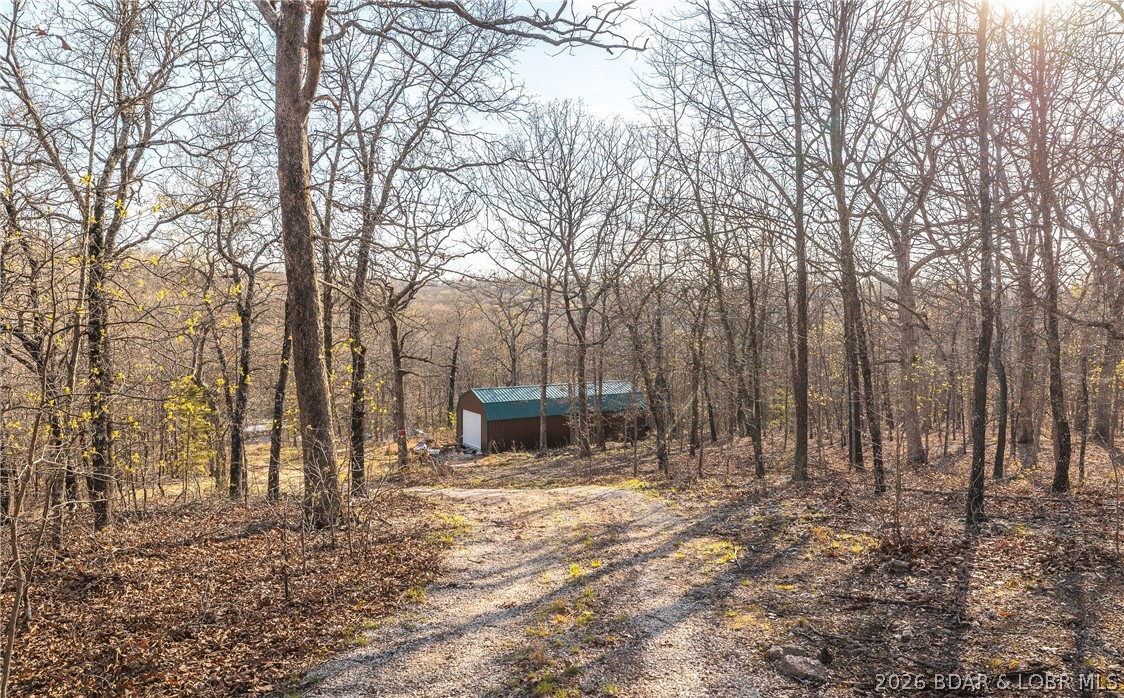 Discover your own slice of the Ozarks with this stunning 15-acre wooded property located just 3 miles from  the Lake of the Ozarks. Featuring beautiful natural terrain with striking rock outcroppings, this land truly captures the rugged charm and serenity the region is known for. Abundant wildlife roams the property, including deer, turkey, and a variety of small game, making it a perfect retreat for nature lovers, hunters, hikers, or anyone seeking peace and privacy. The property includes a 16x40 building with two lofts, offering a blank canvas ready to be finished to your vision—whether that’s a cozy cabin, weekend getaway, or full-time residence. Ideal for homesteading, the land is already equipped with a deep well and a solar-powered pump system, providing a reliable, off-grid water source. If you’re looking for a private, versatile property with natural beauty and self-sufficient potential, this one is worth a closer look.