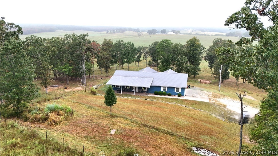 Welcome to 1497 Highway 42 in Iberia, Missouri—just minutes from Lake of the Ozarks! Built in 2016, this custom 4-bedroom, 2-bath home with a private office sits on approximately 6 acres and offers exceptional craftsmanship, comfort, and energy efficiency. The kitchen features beautiful knotty alder cabinetry, quartz countertops, and a stone sink. Bamboo flooring, beautiful tile and carpeted living room highlighted by an electric fireplace. The spacious primary suite includes a private bath, while the laundry room offers a utility sink with a granite countertop.Quality construction includes 2x6 exterior walls, spray-foam insulation, geothermal heating and cooling, and a water softener. The exterior features LP SmartSide siding with a 50-year warranty, a durable metal roof, two-car garage, and stamped-concrete covered patio. An RV hookup is already in place, with plenty of room to build a shop or create the mini farm you’ve been dreaming of. Enjoy acreage, privacy, and country living near the lake!