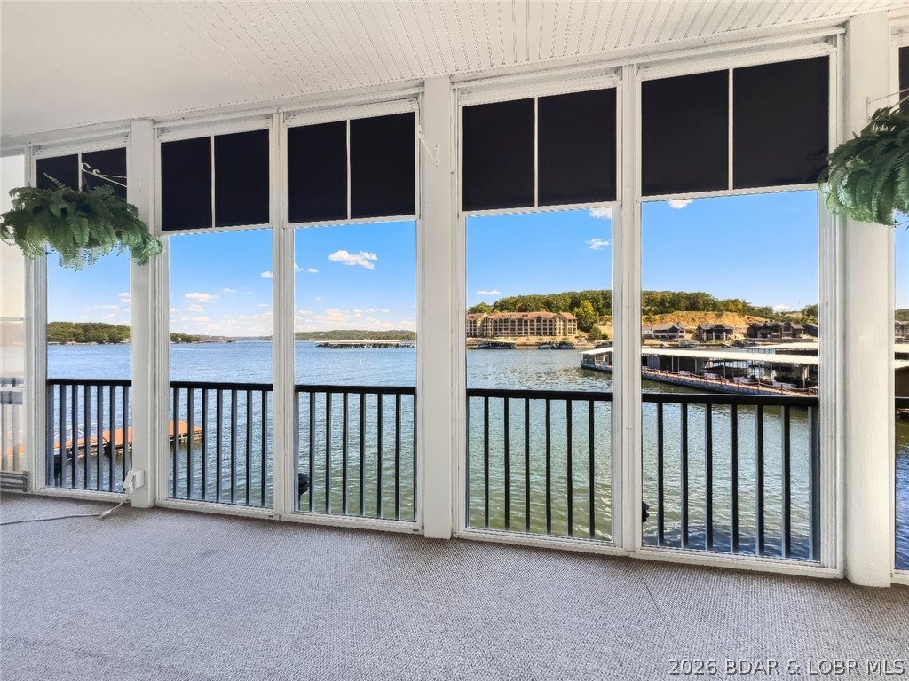 WOW! INCREDIBLE VIEWS OF THE 4-CORNERS! THIS CONDO SITS ON THE WATER’S EDGE AT LAKE OF THE OZARKS. CLOSE TO SHOPPING, GOLF, RESTAURANTS, AND THE HOSPITAL. FRESHLY PAINTED. Updated granite countertops in the kitchen, bath updates, and a HUGE screened-in deck complete with a tinted four-track window system that turns the space into a 3 1/2 season room! FURNISHINGS ARE INCLUDED TOO! No boat docks block your view, and the water is calm for swimming and water skiing.
The unit comes with a 12' x 28' BOAT SLIP AND LIFT, PLUS A PWC SLIP, with additional slips available. Lots of parking as well. YES, THERE IS MORE! A HUGE TWO-CAR GARAGE with overhead floored attic storage for all your water toys, plus a large workbench with pegboard for tools. YOU WILL LOVE THE OVERSIZED GARAGE! The Horizons also offers a community screened porch on Dock One for parties and guests, plus a huge wide breakwater for fishing and sunbathing. This is a SMALL CONDO COMPLEX WITH ONLY 18 UNITS, and rentals are not allowed. DON’T MISS OUT ON THIS GREAT CONDO!!