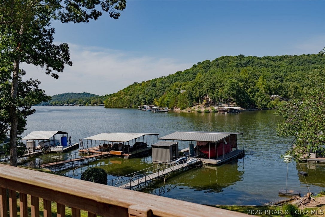 FISHERMAN'S PARADISE 80 FEET OF LAKEFRONT, A 2-WELL DOCK, BOAT RAMP AND DEEP WATER! Here is an opportunity to own your own piece of Lake of the Ozarks without the upkeep of a large lake home. Located in Jackson Hollow Cove at the 3 MM of the Little Niangua, this charming 1-bedroom, 1-bath lakefront cabin sits on a gentle lot with an easy walk to the water. IN A. NO-WAKE COVEThe 2-well dock with two 12x32 slips, a boat hoist, double PWC lift, and swim platform has deep water, 23 feet under the dock! Two decks provide plenty of outdoor living space to take in the lake views. There is a fire pit down by the waters edge. Very close fun lake venues such as The Cave Bar and Grill, Bulldogs Beach House, Pebble Bay Beach Club, and the Naughti Fish Rum Bar. There is room to add-on the home going towards the water, you could add a bedroom and bath and a nice covered porch! Or keep it as it is, and have a place to park your boat without marina fees! Call today this one won't last! (please beware of scammers, this Listing is for SALE, not rent. Photos and information that show it rent at a deep discount are FAKE. Do not send those people any money they are criminals!)
