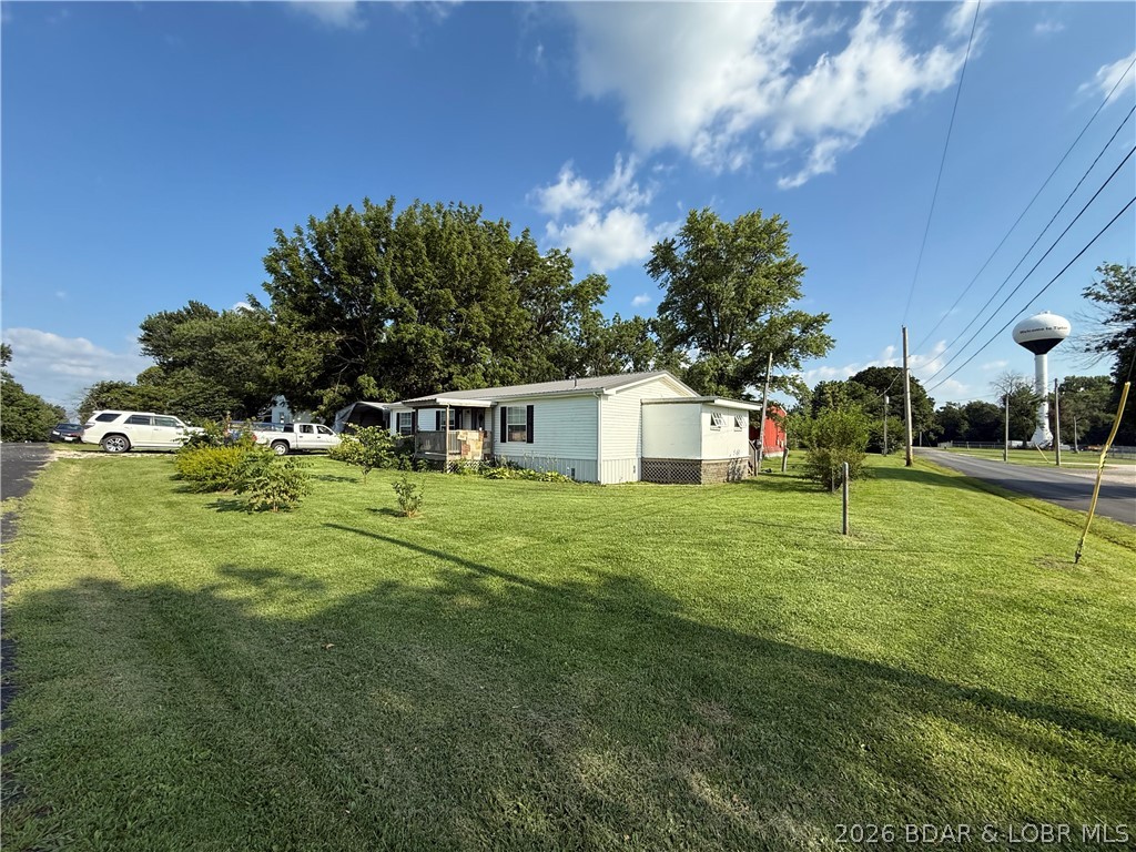 Need serious garage & workshop space without giving up the convenience of living in town? This home sits on 1/2 acre corner lot and the seller has already made improvements. One of the standout features is a detached 1,125 sq ft two car garage/metal building w/ concrete floor, plenty of room for vehicles, tools, hobbies, storage or workshop. The property also includes a carport, storage shed and fenced dog pen. Inside, the seller has continued making updates, including newer kitchen cabinets, deeper countertops, storage, backsplash & new dishwasher. Newer water heater installed, the laundry room entrance widened, & primary bedroom now includes a custom built red oak closet. The back porch has been enclosed w/windows & shelving for more usable space and storage. Outside, updates improved back porch stairs, paver landing, backyard patio, dog pen & gate added to the front ramp. Mature landscaping adds curb appeal, while the backyard offers room for gardening, pets, outdoor projects or relaxing on the patio. With useful updates, abundant storage and an impressive garage/workshop setup, this property offers a combo that can be hard to find in town.