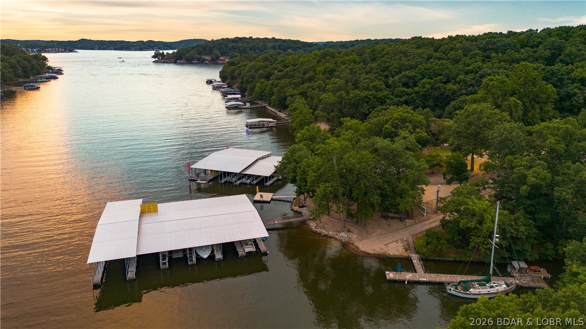 Investment Opportunity at Lake of the Ozarks – 3 Mile Marker, North Shore! Rare chance to own a marina w/tremendous upside potential. This unique waterfront property offers multiple income streams & possibilities for expansion. The property features 20 boat slips, boat ramp, service dock, swim platform, ample parking, & a 40x60 shop building ideal for marina operations, storage, or additional business opportunities. The fuel dock has been updated with new gas dispensers & is ready for a new owner. Included on the property is a charming lakefront home currently operating as an Airbnb, 2 additional rental homes providing steady income, & 4 RV spaces. With room for development and expansion, this property presents a rare opportunity to create a premier waterfront destination. Whether you're looking to expand a marine business, develop additional rental accommodations, or build your vision of the ultimate Lake of the Ozarks marina, this property offers the location, infrastructure, and potential to make it happen. Marinas with this combination of waterfront acreage, existing income, expansion potential, & prime North Shore location rarely become available.
