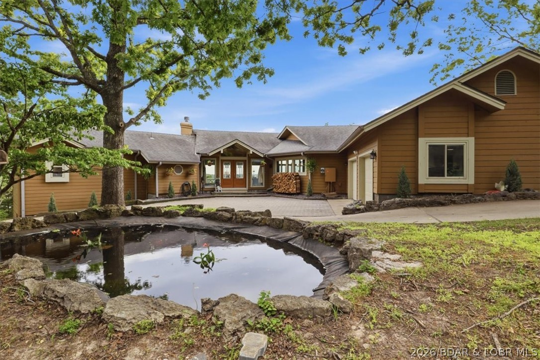 Just 5 minutes from Osage Beach, this stunning 4-bedroom, 4.5-bath home offers the perfect blend of privacy and convenience on 3.6 acres with breathtaking panoramic views of the Osage River and Osage National Golf Course. Each bedroom features its own ensuite bathroom, while the two primary suites on the main level boast beautifully updated spa-like bathrooms. The open-concept floor plan features soaring ceilings, granite countertops, a spacious kitchen with a large island, and main-level laundry for added convenience. A view from nearly every room! The finished walkout lower level offers a bar, spacious family room, two additional ensuite bedrooms, and access to the second deck. A 2-car attached garage, peaceful koi pond, and incredible views complete this one-of-a-kind property. Enjoy the freedom of no HOA or restrictive covenants, all just minutes from the Lake of the Ozarks, boating, dining, shopping, and entertainment—while still enjoying the quiet privacy of your own one-of-a-kind retreat. Whether you're looking for a luxury full-time residence, a weekend lake retreat, or an exceptional Airbnb opportunity, this home truly has it all.
