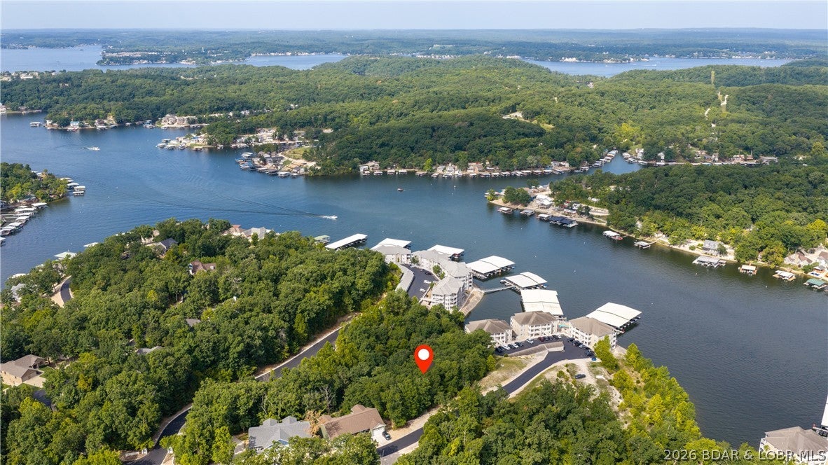 BUILDABLE TIMBERLAKE VILLAGE LOT—TOWNHOME OR SINGLE-FAMILY POTENTIAL. This .48-acre buildable lot with a seasonal lake view offers flexibility for a single-family residence or townhome development. Community water and electric are stubbed to the lot. A separately listed adjacent .92-acre lot is also available, creating an exceptional opportunity for a builder, developer or buyer seeking additional space. Purchase this lot individually and build one townhome, or purchase both parcels for the potential to build three townhomes—one on this lot and two on the adjoining parcel. The two lots could also be combined to create a generous homesite for a beautiful single-family lake-area residence. Timberlake Village amenities include a community pool, clubhouse, fitness center, playground, boat ramp, community docks, boat-trailer parking and paved subdivision roads. Conveniently located in the School of the Osage district near the 5-mile marker of the Lake of the Ozarks. See the recorded Timberlake Village Covenants and Restrictions for building requirements. All proposed construction and use are subject to applicable covenants, restrictions and required approvals. Additional Lot MLS#3590020