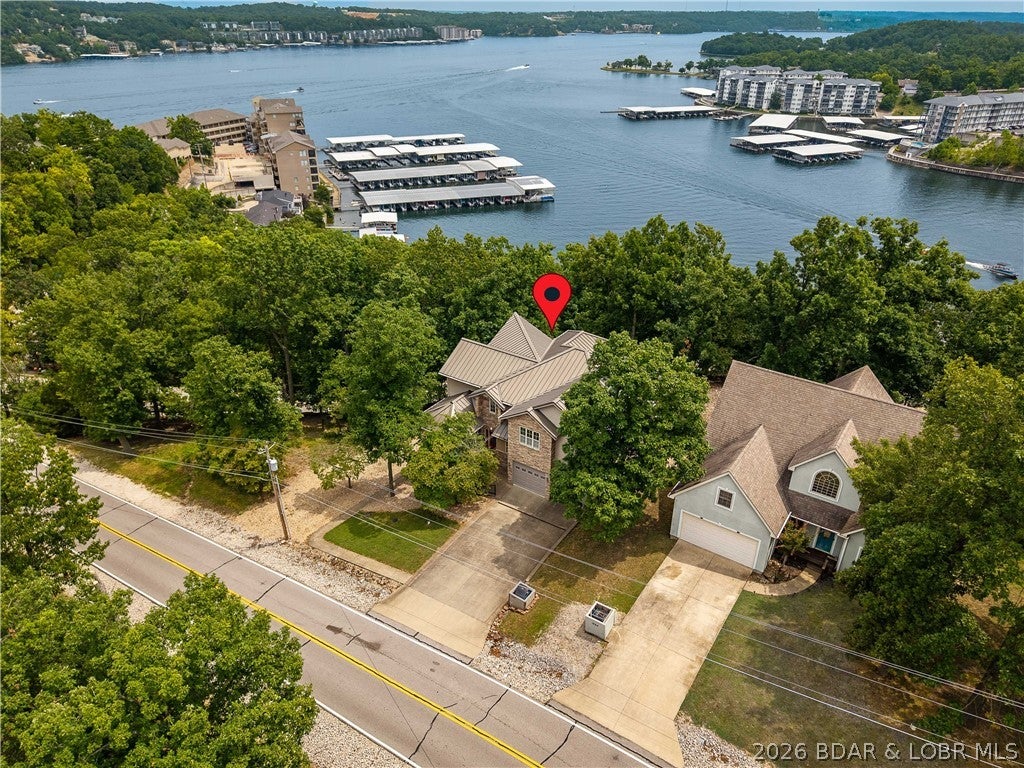 Welcome to this spacious one-owner home in the heart of Lake Ozark, offering over 4,300 square feet of living space, exceptional privacy, and access to the incredible Four Seasons amenities. Featuring 3 beds and 3.5 baths, this home provides plenty of room to spread out, including multiple living areas and a dedicated movie theater that could easily serve as an additional bedroom, bunk room, or flex space. The kitchen is equipped with KitchenAid appliances and opens into inviting living spaces highlighted by real hardwood floors and quality craftsmanship throughout. One of the home's standout features is the abundance of indoor and outdoor living space, with multiple four-season rooms and porches on each level—perfect for entertaining, relaxing, and taking in the beautiful seasonal lake views. The adjoining lot is included, providing added privacy and space that's increasingly hard to find in such a convenient location. Enjoy being close to everything Lake Ozark has to offer while taking advantage of Four Seasons amenities, including pools, playgrounds, boat ramps, and more. A rare combination of space, privacy, lake views, and location—this is Lake Ozark living at its best.