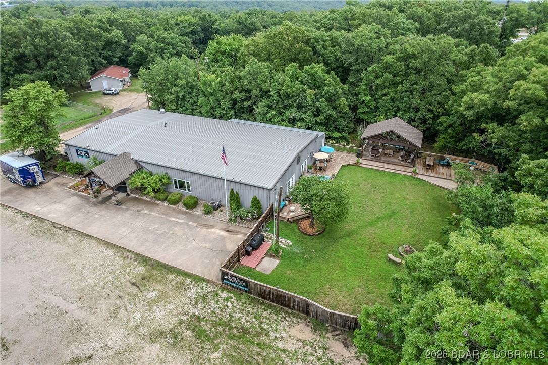Located in Osage Beach, ZONED I-1, This Wonderful COMMERCIAL OPPORTUNITY is Available. 5,600 SqFt Metal/Steel General Purpose Build’g in Nearly Excellent Condition on 1.38 FLAT Acres. Covered Entry w/Double Glass Entry Doors, Huge (Approx 3,400 SqFt) Open Interior Hall, Beautifully Decorated. Could easily be divided into Private Offices, Smaller Areas, Class Rms or used for Lrg Show Room. Full Comm’l Kitchen, Glamorously Remodeled His & Her Baths, Beautifully Maintained Outdoor Fenced-in Flat & Grassy Landscaped COURTYARD w/ 16'x 24' Covered Stage Equipped for Entertainment w/Lighting & Sound. Lrg Outdoor Deck Areas, Fire Pit Area, Huge Grassy Area & More. Lovely Comm’ly Equiped Bar. Flat Park’g for 100+ Cars. Security & Sound Systems. CURRENT USE is Dance Club & Event Center w/200 person capacity. Tall Ceilings & Plenty of Space to Make Your Own. Lrg Storage Area. Sellers will remove the Dance Floor & some other Dance Features. Event Inventory can be Purchased Separately. Private Well & City Sewer. Near the Airport & YMCA. 500 feet off the HIGHWAY. Building & Land Being Sold. All Newer Lighting, Fixtures & Panels Stay. Ideal for So Many Types of Business'. Must see Virtual Tour