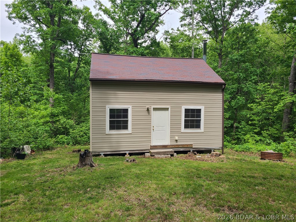 Featuring five acres of wooded privacy and a rustic cabin. Enjoy off-grid living with no neighbors in sight! This tranquil setting is abundant with wildlife and can be used as your personal getaway/vacation/fishing/hunting retreat. Cabin is clean and cozy and has electric panel wired to a generator that could easily be converted to solar, and the cabin is already wired. Outdoor solar lighting. Vacation rentals are allowed. Currently NO utilities connected. Leave it as is for a simply secluded lifestyle, or upgrade with utilities, and with a little work live here year-round. High speed internet through CO-MO is available in this area. Being sold fully furnished. Roads are maintained for a low yearly fee of $50, and Mallard Bay II offers a convenient boat ramp access for landowners. Patriot Point Marina is located at mile marker #60 and is a short 10 minute drive, where you will find fuel, bait, marine services, and grocery store. This property offers endless possibilities. How do you envision making it your own?