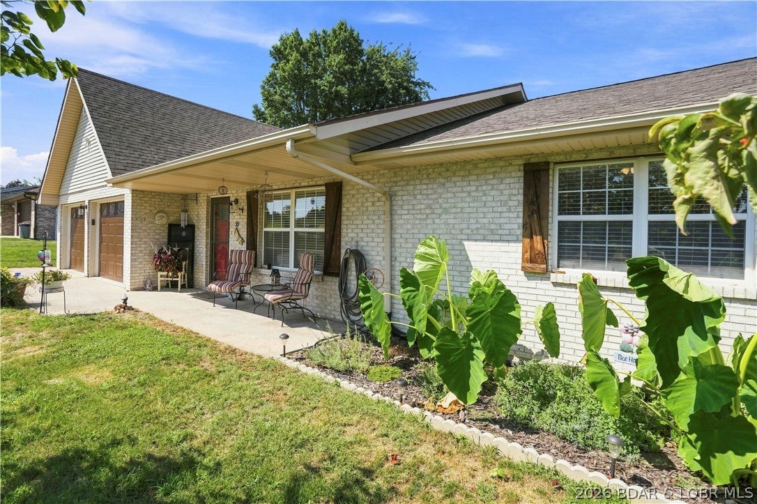 Single-story brick home on a private 0.32-acre lot with vacant land bordering both the north and south sides — no close neighbors on either side. Open floor plan with a large kitchen featuring stainless steel appliances, a center island, and ample cabinet and counter space, plus oversized bedrooms throughout. Primary bathroom newly remodeled. Rear wood deck overlooks open pasture with a pond visible in the distance, plus a cleared area ready for a pool, garden, or outdoor living space of your choice. Attached 2-car garage plus a separate detached garage/shop on a concrete foundation — ideal for storage, a workshop, or extra vehicles. Mature trees and established landscaping. Located 1 mile to downtown Eldon and approximately 12 miles to Bagnell Dam. Quiet gravel-road setting with open sky views. A well-maintained, move-in-ready property offering privacy and space to make it your own.