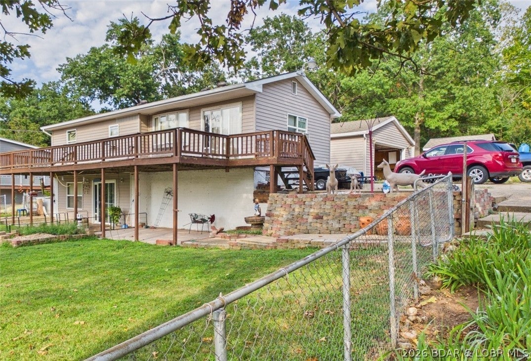 Lake of the Ozarks Fixer-Upper Opportunity! Cove Views & Endless Potential situated on .48 acre overlooking North Buck Creek Cove at the 8MM, this lakeview property is ready for its next chapter. Whether you're envisioning a full-time residence, weekend retreat, or income-producing STR, this renovation-ready property with no HOA restrictions delivers flexibility and value in a prime lakeview location. The main level offers a full bath and 3 bedrooms plus access to the full-length deck - perfect for soaking in the water views. The walkout basement adds a second bathroom, laundry, & the open living/kitchen area that opens to a gently sloping fenced yard ideal for kids & pets. Behind the home, a large multi-function garage/bunkhouse offers parking for 2+ vehicles plus 4 additional rooms suited for guest quarters, a hobby space, or extra living area. A large pole barn with electricity provides more storage & workspace. This home needs renovation but has great bones, solid potential, and an unbeatable setting. Enjoy peaceful cove living with easy access to Lake of the Ozarks boating, fishing, dining, and entertainment. Bring your vision & make this one-of-a-kind lake property your own!