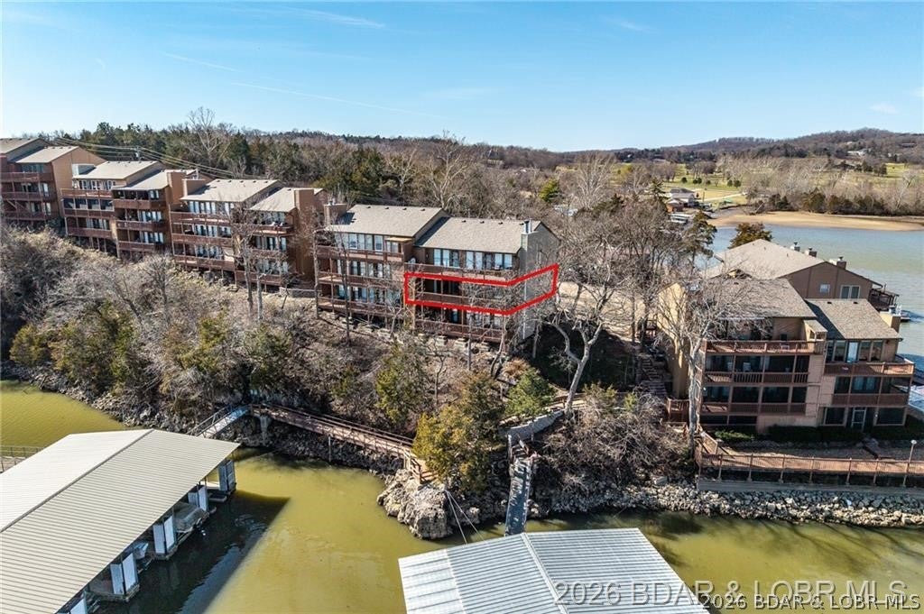 The best lake place isn't the one that gives you more to take care of. It's the one that makes it easier to get here more often. That's what makes this condo different. Your boat has a home in the included 10x24 slip with 4,500 lb lift, the pool is waiting when you want a break from the lake, and nearly everything is covered through the HOA except electricity. Even the next major improvement is handled—NEW FRONT & LAKESIDE DECKS ARE COMING FALL 2026, with sellers paying the special assessment. But convenience is only part of the story. Its elevated setting captures long main-channel views, while windows from multiple angles make the water feel like part of the condo rather than something you only see outside. The lakeside deck connects to both the living room and primary suite, keeping that view close throughout the day. Inside, granite countertops, newer flooring, fresh paint and updated fixtures complement HVAC (2023), water heater and softener (2022). Add dock storage, a fish cleaning station and a location minutes from Ha Ha Tonka, Old Kinderhook, golf and lakefront favorites. Some properties give you a place at the lake. This one gives you fewer excuses not to use it.
