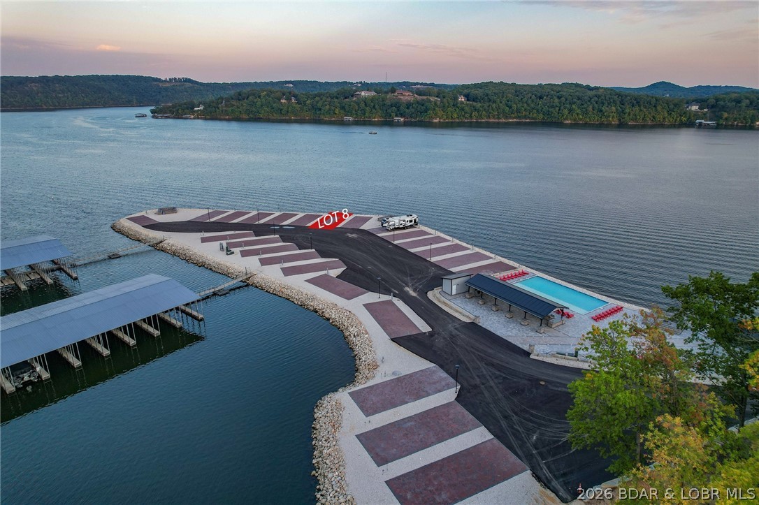 Welcome to Paradise Point RV Resort—one of the most exciting opportunities to own at the 38MM of Lake of the Ozarks. Set on a stunning peninsula with incredible panoramic views, this development offers both lakefront & second-tier RV lots now available for individual purchase. Every site is built right—level concrete pads with full hookups including 100-amp electric, water, sewer, and Wi-Fi—designed for comfort, convenience, & long-term value. An HOA ($200/month) keeps the community maintained and looking sharp. The amenities set this apart: lakefront pool, sandy beach, swimming dock, marina with boat slips available, covered pavilion with grills, large stone fire pits, bathhouse with laundry, and fenced dog park. Whether you want to relax or entertain, it’s all here. Leave your RV on-site year-round and skip the hassle of hauling. When you’re not using it, rent it out for additional income—strong demand makes this a smart investment as well as a lifestyle play. Located in Sunrise Beach with easy access by land and water, this is lake living without the typical price tag or maintenance. Multiple lots available with varying prices—secure your spot now before they’re gone.