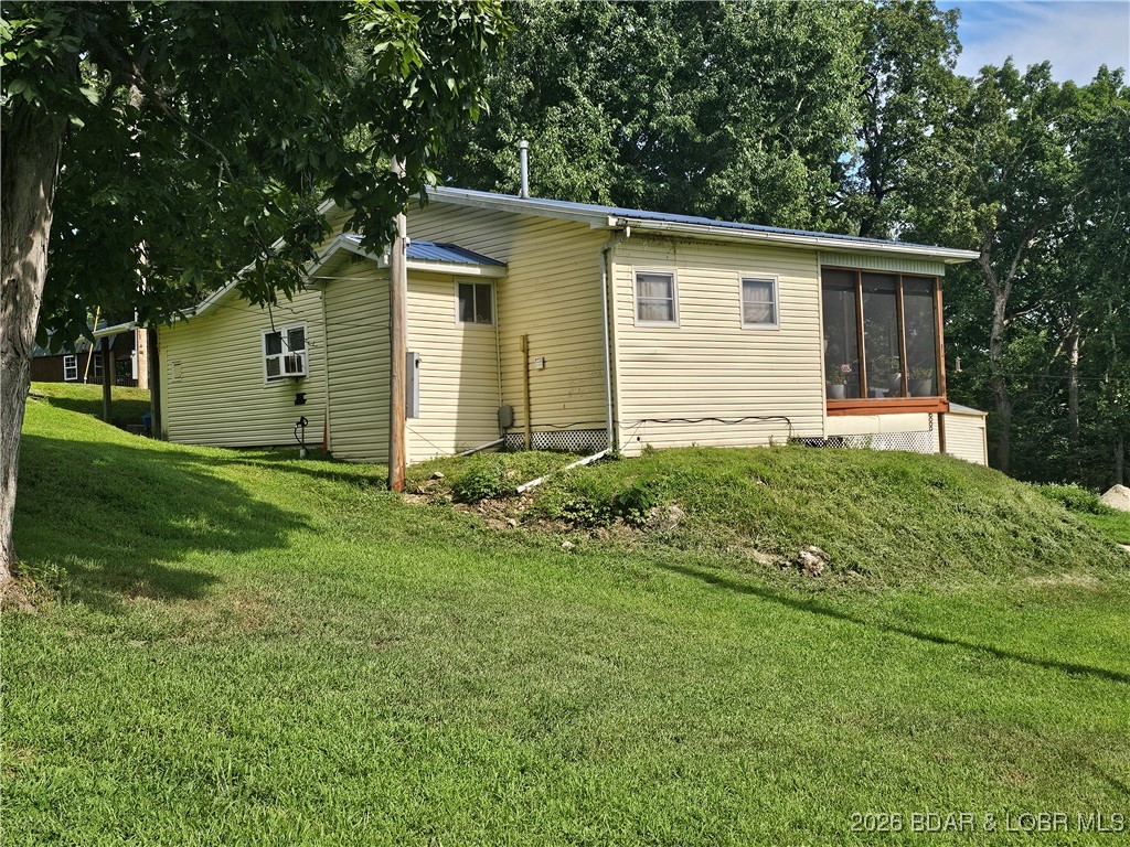 Lake of the Ozarks – Golden Beach opportunity! Nearly 2 acres in the sought-after Golden Beach area offering privacy, flexibility, and investment potential. Originally a singlewide transformed into a charming cabin with thoughtful additions, this property is perfect for a weekend getaway, full-time residence, or VRBO rental. CoMo Connect high-speed internet available! Features include a detached drive-through garage ideal for boat storage, vehicles, and lake toys, plus additional parking for guests. An unfinished bunkhouse currently provides storage but could easily be finished into a second rental cabin or guest quarters for added income potential. Private well and septic already in place.  Lake-area setting offers a peaceful atmosphere while remaining close to boat ramps, restaurants, entertainment, and all the recreation Lake of the Ozarks is known for. Multiple lots provide added flexibility for expansion or future development.