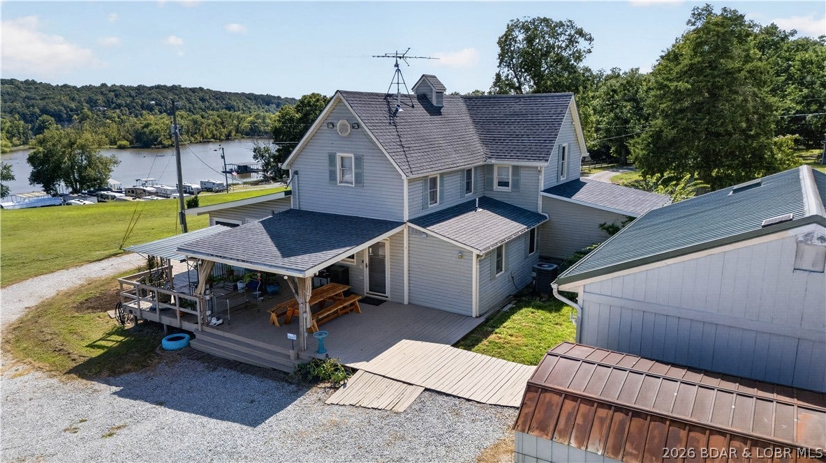 Beautiful 4-bedroom, 2-bath Lake of the Ozarks home situated on 3.5+/- acres! This well-maintained farmhouse has been thoughtfully updated over the years while preserving the unique character and charm that makes it stand out. Inside, you'll find four spacious bedrooms, a large and inviting living room, separate den, and dedicated dining room. The primary suite features a private ensuite bath and an impressive walk-in closet with plenty of storage. Outside, the property offers tons of parking and versatile garage/shop space with room to accommodate up to five vehicles. The 3.5+/- acres provide plenty of room to spread out, while your covered dock with swim platform on the Lake of the Ozarks and 80 ft of waterfront gives you the opportunity to enjoy boating, fishing, swimming, and long days on the water. Located just off paved roads with convenient access to both Lincoln and Warsaw, this property offers a great combination of acreage, lake access, storage, and farmhouse charm!