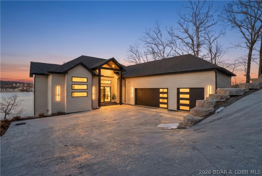 This striking new-construction estate commands panoramic main channel views with 6,300 SF of refined living across 3 levels. 6 private suites (4 lakeside) and 9 baths surround a dramatic great room with soaring ceilings, designer lighting & bold finishes throughout. Two gourmet kitchens feature top-end gas appliances, custom cabinetry, statement backsplashes, hidden butler's pantry & wine bar. The primary suite is a true retreat—fireplace, spa-style wet room with dual shower systems, freestanding soaking tub, heated floors, floating vanities & custom walk-in closet with private laundry. Four uniquely designed guest suites offer custom tile showers, shared living spaces & half bath/laundry on each floor. The entertainment level steals the show: full kitchen, fireplace, 6th suite & game room with dual collapsing sliders opening 30' to a patio overlooking the massive heated/cooled pool—prepped for firepits, outdoor kitchen or lounge. There is a deep 3-car garage, gentle driveway, abundant parking & cart path to pool. With a dock already on standby, don't miss the opportunity to live the best summer of your life and schedule a showing now!