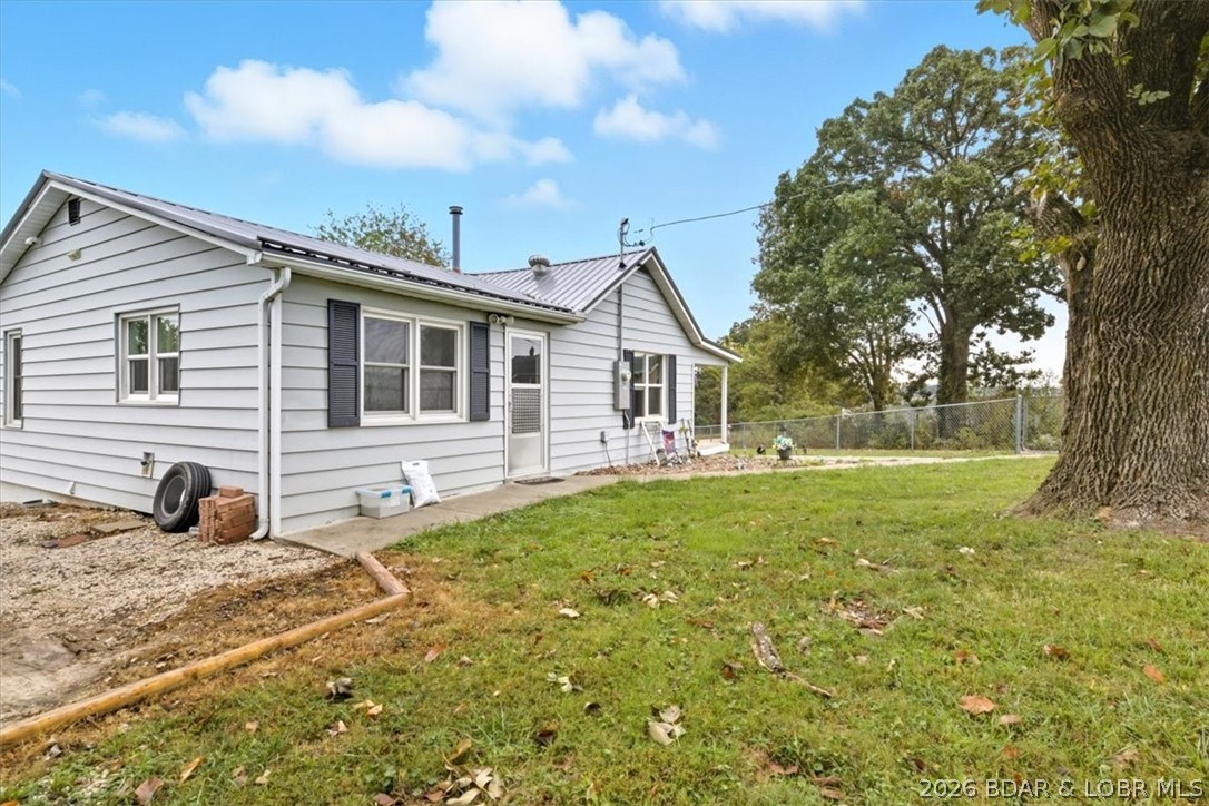 This inviting 2 bedroom, 1 bath home just outside the city limits of Versailles, MO is MOVE-IN READY! Featuring a delightful mix of original hardwood floors and new LVP flooring, this home offers a blend of classic appeal and modern convenience. Fully updated kitchen with soft-close cabinets, new stainless steel appliances and a farmhouse sink. Additional updates include a durable metal roof, fenced yard, recently upgraded HVAC, plumbing, and electrical systems, providing peace of mind and efficiency. Enjoy the convenience of main level living complemented by a partial  basement, ideal for use as a storm shelter, storage area, or even a canning cellar. Benefiting from city utilities despite being outside city limits, residents can enjoy the reliability of essential services along with the high-speed Co-Mo Connect internet, making it easy to work from home or stream for  entertaining. Located just minutes from downtown Versailles, residents have easy access to local amenities, annual events like the Apple Festival, and excellent schools. Don’t miss the chance to make this versatile home yours—schedule your showing today!