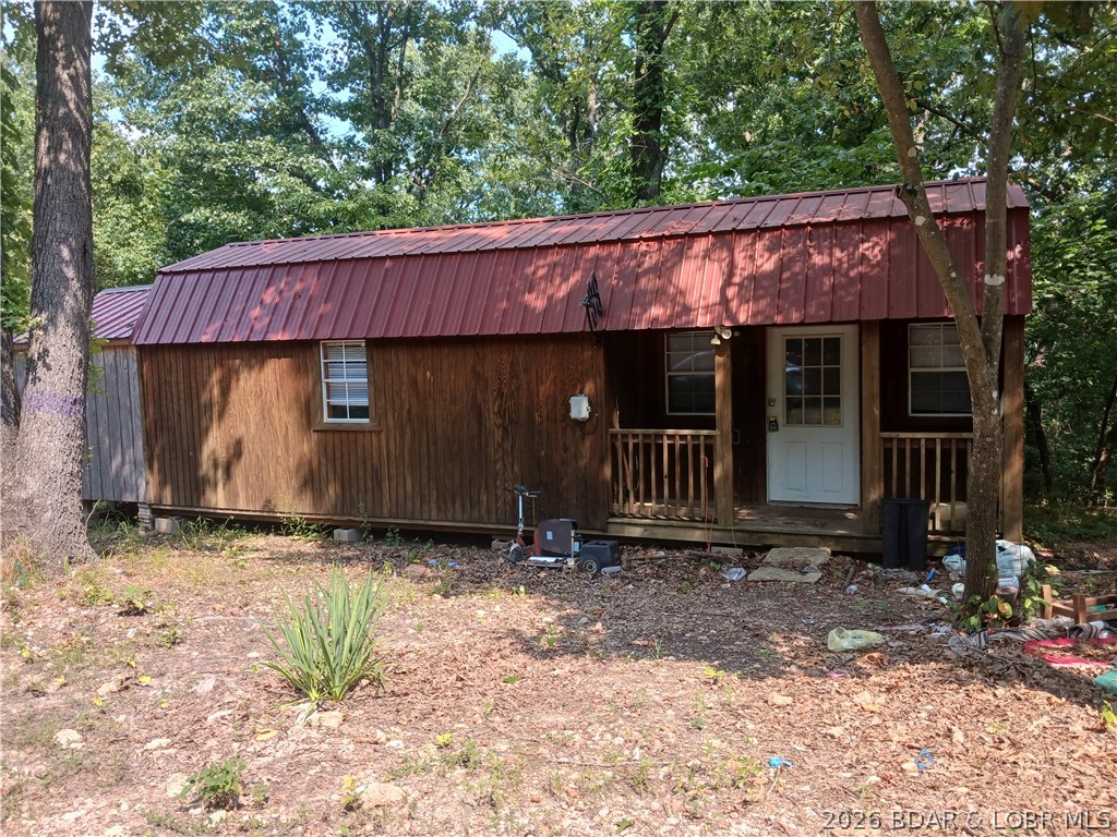 Looking for an affordable weekend retreat or small full-time home? Come take a look at this manufactured cabin located on one of five lots with electricity, community water and private septic system.  The cabin's interior has been insulated, sheet-rocked and painted, has kitchen cabinets in place and a bathroom. This cozy cabin is easy to heat with portable heating devices and a wall-installed air conditioner. With a little TLC, this property can be great for weekend or summer retreats, or a full-time residence  for the person who likes seclusion but also likes to be within a short driving distance to conveniences. The cabin is placed on one of the five lots belonging to the property, each of which have their own water hook-ups for additional tiny homes or campers (a possibility for additional income. Rent it out by the week, month, or year. There are no restrictions. For those who enjoy fishing and other water sports, it's only a short drive to the 54,000 acre Lake of the Ozarks and the Wigwam Public Boat Launch. Schedule your showing today!