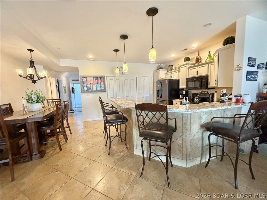 Welcome to lake life at Millstone Condos, perfectly located at the 7MM of the Lake of the Ozarks main channel! This fully furnished 3-bedroom, 2-bath ground-floor condo offers easy, walk-out access from your patio straight to the dock. The beautiful kitchen features granite countertops and brand-new stainless-steel appliances, while the screened-in patio with sun shades creates the perfect spot to relax and enjoy the lake lifestyle. A 12x32 boat slip with a 10,000-lb boat lift is included, along with a breakwater to help protect the docks. Millstone offers the convenience of full-time on-site maintenance staff, so you can spend less time worrying about upkeep and more time enjoying the lake. Located close to popular restaurants, entertainment, and all the fun the Lake of the Ozarks has to offer. Ready to enjoy—just bring your lake toys!
