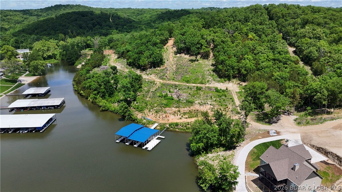 Discover this incredible 31.35-acre gentle lakefront property boasting 1,500 feet of shoreline with no restrictions or subdivision requirements. Perfect for a private estate, subdivision, townhomes, condos, or a commercial business, the land features roads & excavation already completed, along with a concrete boat ramp, a 2-well dock, and a high-capacity well capable of connecting up to 15 homes. Ideal for recreational activities, hunting, or major development, this unrestricted property provides exceptional water access and endless potential just a few miles off Highway 5 at 835 Greenview Dr in Camdenton. Highlighting the land is an exceptional 4,000 sq ft Shouse/commercial/industrial shop built for heavy use. The facility features two spacious 14' garage doors, 21' ceilings, 480-volt 3-phase electric, and a new mini-split system for heating and air conditioning. Poured with a durable 7 sack mix, both the extra-thick 8-inch concrete shop floors and matching driveway can handle demanding operations. Perfect for an RV, storage, business space, or a unique live/work setup, the building is completed with a 1,000-gallon septic system alongside the property's robust well infrastructure.