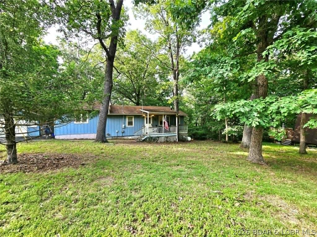 This 2-bedroom, 2-bath home offers lake access and is situated on just under an acre in a peaceful neighborhood. Enjoy the convenience of parking your boat at the community day dock on the Osage 4 MM, along with access to the community's covered, screened pavilion—perfect for family picnics, birthday parties, and gatherings. Designed for comfortable year-round living, this home features a one-level floor plan plus a versatile bonus room that could serve as additional sleeping space, a sitting room, game room, home office, or even future bathroom expansion. The heated unfinished basement includes a quality Maytag washer and dryer set and offers excellent storage with built in shelving. Step outside to the covered patio overlooking the backyard, where you'll enjoy privacy, abundant wildlife, and plenty of room for outdoor activities. There's ample space for yard games, gardening, or creating the perfect firepit gathering area. A one-car garage/workshop provides additional space for hobbies, projects, or storage. If you're looking for an affordable lake-area property with lake access, this one is worth a look!