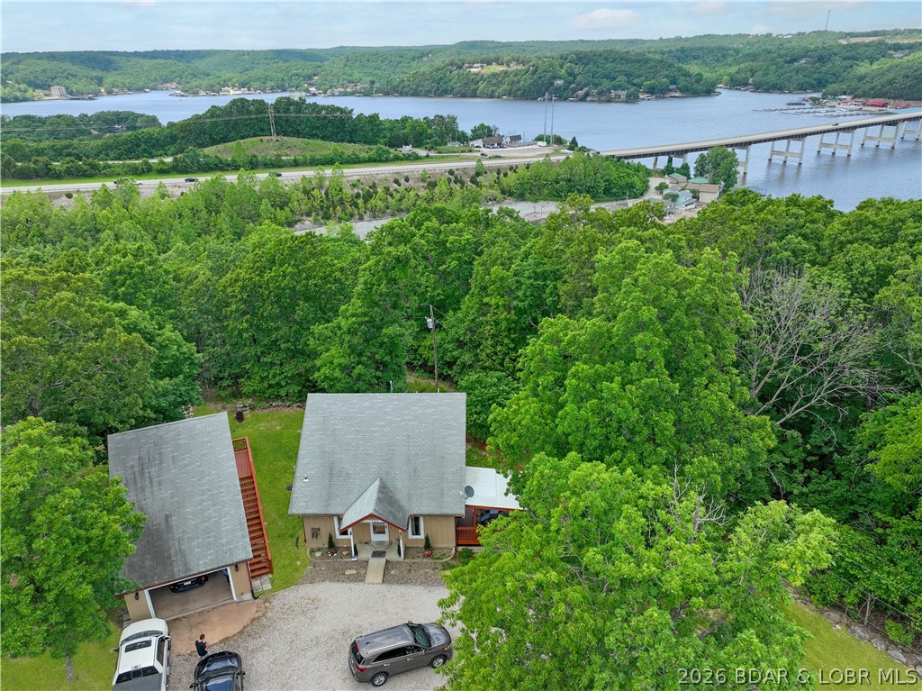 Come see 107 View Dr. in the Niangua View Subdivision of Camdenton. This well-maintained home on a gentle one-third acre lot offers a quiet atmosphere and a seasonal lake view, located just five minutes from a boat launch!  The main floor features a comfortable living room with vaulted ceilings and wood floors, a large eat-in kitchen, and a primary bedroom with extensive built-ins and easy access to the laundry and a bathroom with a new flooring and a walk-in shower. Pantry storage under the stairs is also a plus.  Upstairs, you will find a loft bedroom and a large full bathroom.  Bonus Space: A 16x18 heated and cooled 3rd bedroom above the garage, perfect for an office, craft room or game room.
- Garage & Storage: A heated and cooled 1+ garage with a workshop area, plus a separate storage shed with stylish barn doors.
- Outdoor Living: A covered deck and a newer wood-fenced yard, ideal for children or pets.
 New septic laterals and the seller has done several things like new water heater, new anti-freeze exterior faucets, new carpet.  Its ready for you to enjoy! 
The subdivision has a community dock.  Seller is checking to see if any slips would be available.
