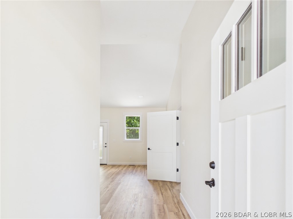 More space. More flexibility. More possibilities. This 4-bedroom, 3-bath home in Woodhaven Estates offers a layout designed for the way life actually happens—with room to gather, room to spread out, and spaces that can change with your needs. The open main level brings the kitchen, dining, and living areas together beneath vaulted ceilings, featuring upgraded cabinetry, a large center island, and access to the rear deck overlooking a peaceful wooded backdrop. The private primary suite includes dual sinks, a walk-in shower, and a spacious walk-in closet. Downstairs, the finished walkout lower level adds a second living room, two additional bedrooms, a full bathroom, generous storage, and a versatile bonus room ideal for an office, gym, playroom, media room, or non-conforming fifth bedroom. An oversized 2-car garage, upper deck, lower patio, and upcoming neighborhood playground and designated dog park add even more function and appeal. Located within Laurie city limits and the Camdenton School District.