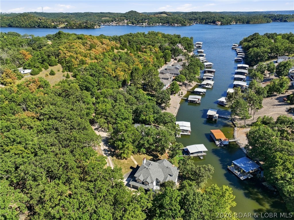 Experience lakefront living on the “Quiet Side” of Lake of the Ozarks with this impressive multi-level 5-bedroom, 3.5-bath estate. Situated on 1.45 acres with no HOA, ample parking, and approximately 195 feet of lakefront, you’re just minutes by water from Capt. Ron’s, The Cave Bar & Grill, and Bear Bottom Resort. Designed for entertaining, the home features a chef’s kitchen, dining room, spacious living room, billiards room, and a deck overlooking the water. The primary suite is a private retreat with a three-sided propane fireplace, walk-in closet, and spa-inspired bath. Upstairs offers three additional bedrooms and a full bath. The walkout lower level provides exceptional flexibility with a second kitchen, family room, ¾ bath, and bedroom spacious enough for two king beds—ideal for extended family or guests. Outside, enjoy new deck railings, a covered dock with 10x28 slip, double PWC lift, whole-house generator, and freshwater tank. The protected cove has remained accessible year-round to date. Schedule your private showing today and start living the Lake of the Ozarks lifestyle!