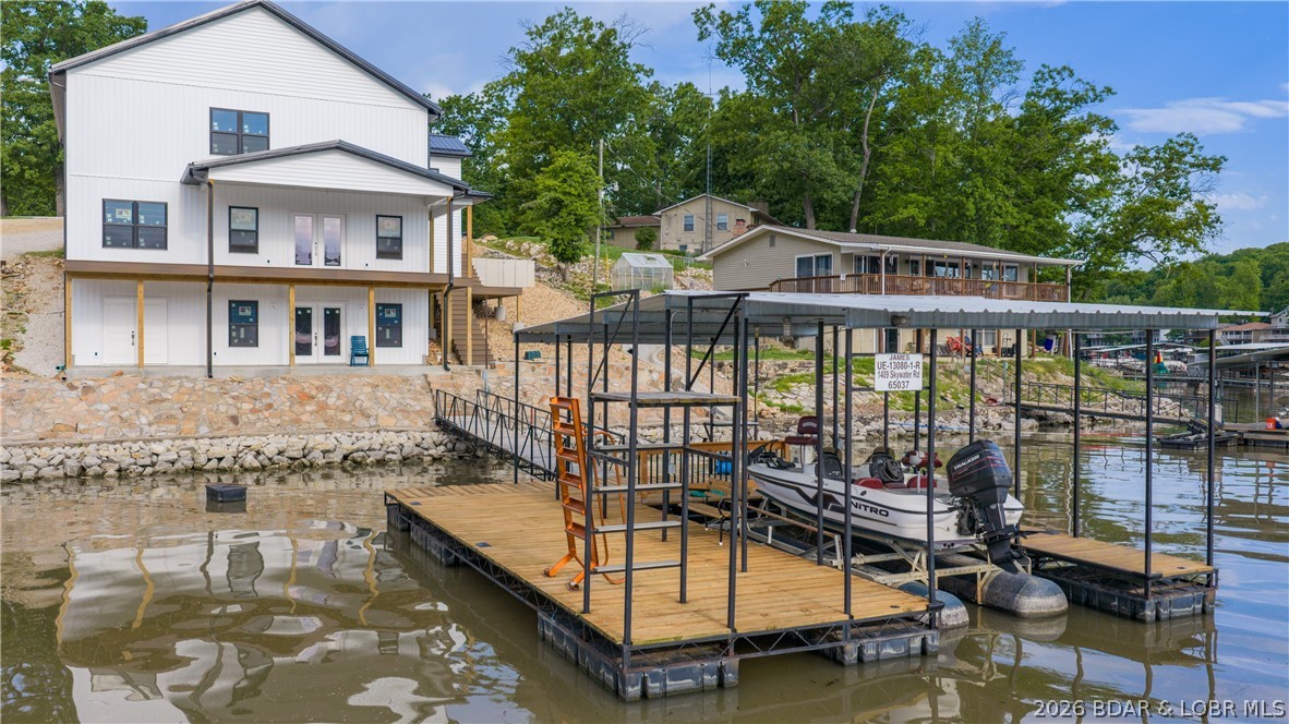 Bring your lake vision to life at 1409 Skywater Rd! This new construction shell is ready for the next owner to finish to their taste, style, and budget. With 3,528 sq ft framed for 4 bedrooms, 3 full baths, and 1 half bath, this 3-story walkout design offers the space and flexibility to create a custom lakefront retreat. The home sits on 99 ft of waterfront in Skywater Estates with cove protection and main channel views at the 45 MM. Enjoy covered and open deck areas, a private dock directly in front of the home, 10x30 slip, boat hoist, PWC lift, wet steps ladder, seawall, and rip rap. Metal roof, vinyl exterior, poured foundation, shared well, and septic are already in place. Sold in its current stage of construction, this is a rare opportunity to take over a lakefront project without starting from scratch. Finish it your way and enjoy the Lake of the Ozarks lifestyle.
