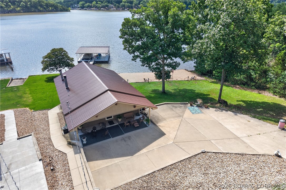 Lakefront living on the desirable 53 Mile Marker! Nestled in the calm waters of Climax Springs, this home offers the perfect combination of waterfront enjoyment, privacy, and room to spread out. Lovingly owned and meticulously maintained by the same family since 2008, this property is ready for its next chapter of lake memories. Situated on two lots, this unique offering features a rare beach area created on the additional lot, providing the perfect place for swimming, relaxing, and lakeside gatherings. The gently sloping lot leads to an upgraded concrete 2-slip dock, making it easy to enjoy boating, fishing, and everything Lake of the Ozarks has to offer. The home features 3 bedrooms, 2 bathrooms, and comfortable living spaces designed to capture beautiful water views. Multiple outdoor entertaining areas, expansive concrete parking, and a level lakeside yard create the ideal setting for weekend getaways or full-time lake living. Additional highlights include an oversized detached 2-car garage with plenty of space for vehicles, lake toys, and storage. A rare opportunity to own a turnkey lakefront property with extra land, beach frontage, and an upgraded dock.