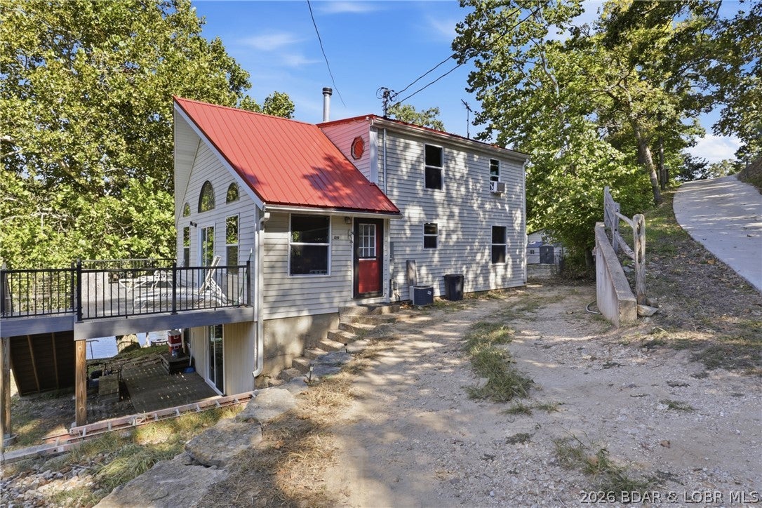 TURNKEY LAKEFRONT RETREAT on the calm waters of the 7 MM of the Little Niangua! This 2-bedroom, 2-bath home features a spacious loft with room for multiple beds, making it ideal for lake weekends, entertaining or vacation rental use, with strong Airbnb bookings when previously rented. Cozy up to the wood-burning stove, providing warmth throughout the home, complemented by a heat pump for year-round comfort. Enjoy the beautiful composite deck wrapping around the home, perfect for outdoor dining, entertaining and relaxing by the water. All-new windows and sliding doors bring in abundant natural light and connect the indoor and outdoor living spaces. With approximately 128 feet of lakefront, the property includes a private one-well dock with double jet ski lift. Enjoy calmer water that's perfect for swimming, kayaking, fishing or simply floating the day away. The unfinished walkout basement already has a full bathroom and offers incredible potential for additional living, sleeping, game or entertainment space. Add ample parking and generous sleeping capacity, and this turnkey lake retreat is ready to enjoy from day one!