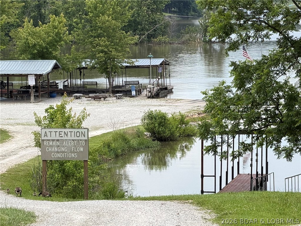 Endless  Potential & Year-Round Lake Views Under $200K!
On 84 Mile Mark in Warsaw, MO! Nestled on a spacious double corner lot, this Tier 2 property offers beautiful, year-round lake views and complete lake living without the hefty price tag. Right across the road is the public access and community dock.
The home is a blank canvas ready for your personal touch. Materials are already on-site and included to finish the gorgeous tongue-and-groove walls and floors, leaving room to build quick equity. Outside, the expansive double lot is perfect for a garden or custom landscaping.  
A big Shop for a RV with a work area and storage.