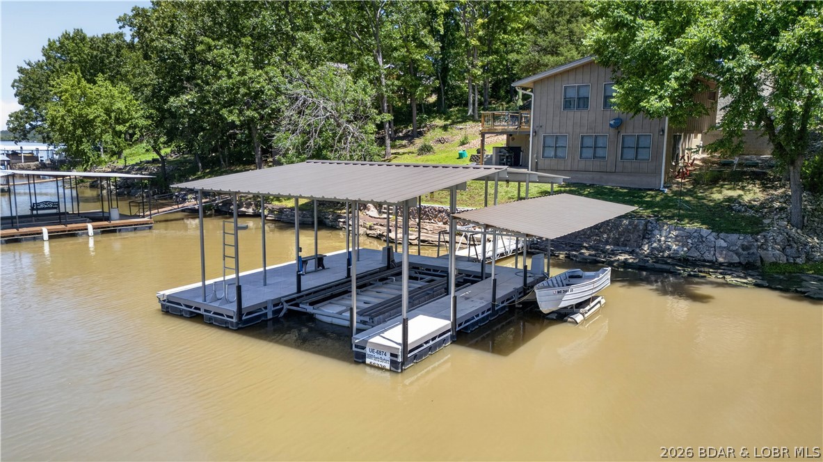 Lake life is all about spending your days on the water & your evenings enjoying everything the Lake of the Ozarks has to offer—and this beautifully remodeled home at the 80 Mile Marker puts you right in the middle of it all- also a peaceful place to relax when the day is done. This extensively updated 2-bedroom, 1.5-bath home offers the low-maintenance lake lifestyle you've been searching for. Recent renovations include new flooring, fresh paint, and a completely updated kitchen w/new cabinetry, creating a move-in-ready retreat that's designed for enjoying the lake rather than working on projects. Inside, the spacious living area showcases beautiful lake views & provides plenty of room for gathering with family & friends. Step outside to the large deck & covered patio where you can entertain, grill, or simply enjoy watching boats pass by. The property also features abundant concrete parking on two levels, making it easy to accommodate guests on busy lake weekends. The dock sits in good water and provides quick access to endless days of boating, fishing, swimming, and exploring the lake.