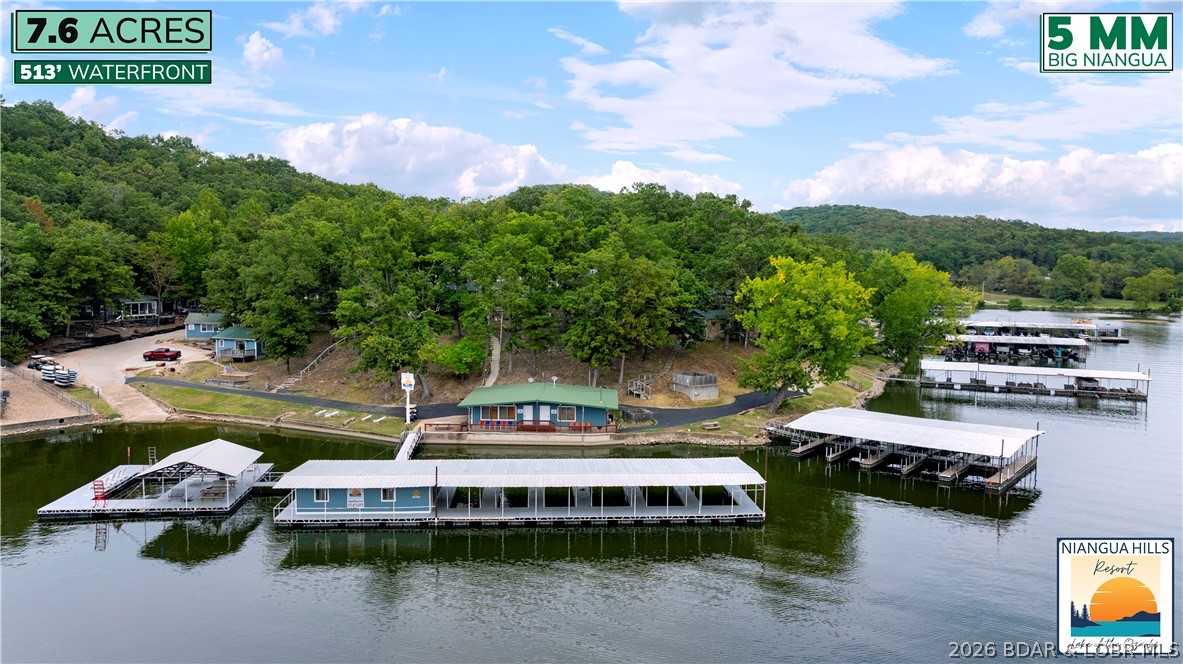 Seize a rare chance to own a piece of Lake of the Ozarks history with Niangua Hills Resort! This meticulously updated, turn-key business dates back to the 1940s, blending vintage charm with modern convenience. Situated on the 5-mile marker of the Big Niangua Arm, the property spans over 7.6 acres with 513 feet of calm, cove-protected waterfront. The resort offers 3 homes & 12 diverse, original cabins that were all extensively renovated with new kitchenettes, appliances, bathrooms, flooring, & furnishings to give them a fresh feel while preserving their historic character. Guests can enjoy a host of new amenities; like a swimming pool, playground, yard games, kayaks/paddleboards, fire pits, boat trailer parking, wi-fi, keyless entry & a general store. The resort's large pavilion is perfect for hosting parties and reunions, plus the property can currently accommodate up to 23 boat slips with room to add more. Guests love the large swim dock and rare, enclosed fish house. With a rich history and comprehensive upgrades, Niangua Hills Resort is an ideal opportunity for someone looking to continue a beloved lake tradition as a successful business and there is room to expand.