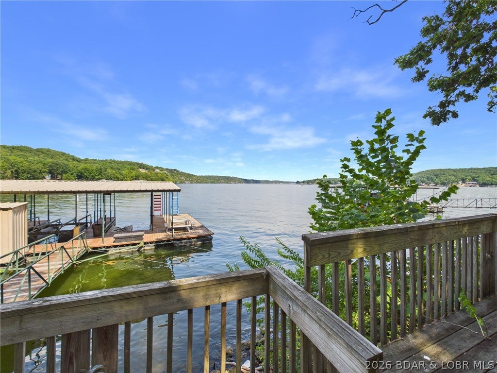 THE VIEW. THE LOCATION. THE LAKE LIFESTYLE. This is one you need to see for yourself! Tucked into a protected cove at the 24 Mile Marker of the Osage Arm, this charming lakefront home delivers incredible main channel views that photos simply don’t do justice. Offered fully furnished and Turn key, this 3-bedroom, 2-bath home offers nearly 1,400 square feet and is ready to enjoy from day one. Situated on 2 lots with approximately 110 feet of lakefront, you’ll appreciate the abundance of parking, blacktop all the way to the door, and a beautiful tree-shaded setting. Enjoy the large deck, unique martini deck, and those amazing views! The 2-well dock includes Wet Steps, a dive platform, swim platform, and boat hoist. Private well and septic are in place, and all furniture, décor, and decorations stay. Conveniently located near popular restaurants and entertainment by land or water. Whether you’re looking for a personal lake getaway or a property with vacation rental potential, don’t just drive by—come see the view for yourself!