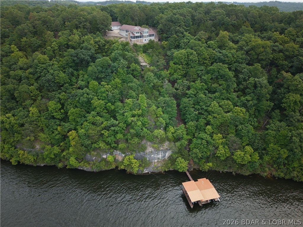 This is a lakefront property buyers wait years to find. Set behind a gated entrance on 56 fenced acres, this 3-bedroom, 3-bath home offers sweeping bluff-top lake views, a 3-well dock & the rare combination of lakefront living, acreage and true privacy.
Walls of windows showcase the water views, with plenty of space to make it your own. The acreage opens the door to endless possibilities. Cleared sections & established paths make it easy to explore, while an elevated deck among the trees creates a place to watch wildlife, unwind or take in the surroundings.

A tram provides convenient access toward the shoreline, where the dock offers generous space for boats, lake toys, swimming & long days on the water. The 6-car garage is a standout, complete with a wood stove & vehicle lift—perfect for a workshop, equipment storage, hobbies or anyone needing serious garage capacity.

Whether you envision a full-time estate, weekend escape, recreational property or a place where lake life & acreage finally come together, this one-of-a-kind offering gives you room to live, explore, work & play—all in one unforgettable setting. SELLER FINANCING AVAILABLE WITH ACCEPTABLE TERMS