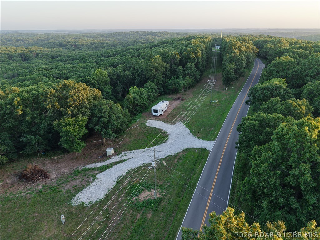 Discover the possibilities on this 3.37-acre unrestricted property with an impressive 880 feet of highway frontage, just minutes from the Lake of the Ozarks. Whether you're planning to build your dream home, create a weekend getaway, or enjoy the flexibility of unrestricted land, this property is ready for you. Utilities are already in place, including electric, private well, and lagoon, and two build sites have been cleared and leveled, saving you time and expense. A 36-foot fifth-wheel camper with three slide-outs is included, allowing you to enjoy the property immediately, or the seller will remove it if preferred. Co-Mo Connect fiber internet is scheduled for installation. Located just 4 minutes from Wigwam Boat Ramp and approximately 15 minutes from Stover, Versailles, and Laurie, you'll enjoy quick access to boating, fishing, shopping, and dining. Properties offering unrestricted acreage, existing utilities, multiple build sites, and excellent highway frontage this close to the lake are hard to find. Bring your builder, your camper, or your vision and make this property your own.