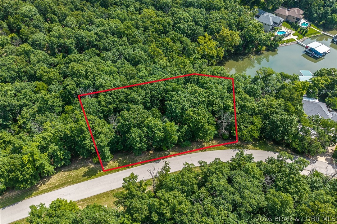 This premier Lakefront lot at The Villages at Shawnee Bend delivers the ultimate Lake of the Ozarks lifestyle with direct water access and breathtaking shoreline views. Arrive through the iconic grand waterfall entrance and enjoy a community known for its upscale amenities and attention to detail. Residents have access to a community marina, elegant clubhouse, multiple pools, championship tennis courts, and pickleball facilities, along with park and playground areas. With paved roads and underground utilities already in place, this lot is perfectly suited for a custom lakefront home with dock potential. A rare opportunity to own lakefront property in one of the lake’s most distinctive communities.