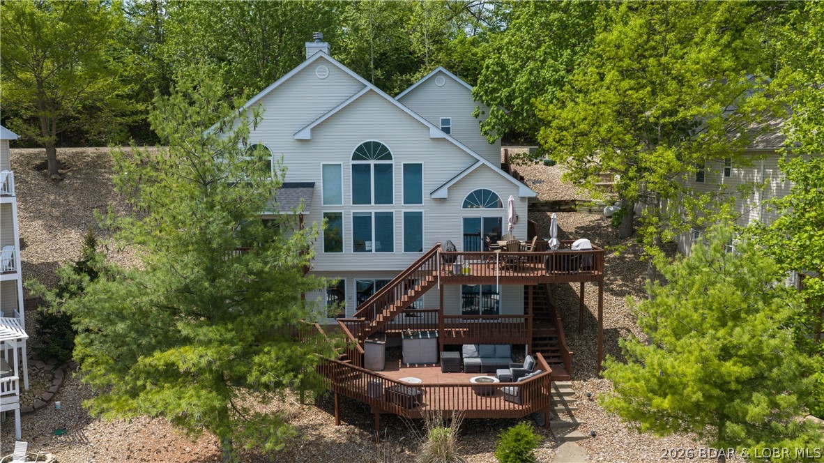Incredible lake home from the inside & the out, located in a nice taken care of neighborhood. This 4bed/3.5bath home has a multitude of features you will enjoy. Massive wall of windows in the main living area on the lakeside-providing stunning natural light, cathedral ceilings & offering breathtaking views of the Gravois 2MM. Living room features large stone gas fireplace, new carpet, open concept to dining room/kitchen & access to open deck/grilling area. Kitchen contains custom cabinets, granite counters & a large pantry with additional beverage fridge inside. Each bedroom offering a lakeview with 2 bedrooms being en-suites w/ walk-in closets & large bathrooms. Lowest level features a nice family room, 2 bedrooms & deck access with tons of room offered for entertaining. A few more steps off the deck to your concrete dock with large swim platform, storage shed & 2 slips; a 12x36' and a 8x20' (under roof) slip. This updated home also comes TURN-KEY so you don't have to worry about moving furniture in! You'll find that this property provides an inviting atmosphere with it's pristine condition, updated finishes & a functional layout that's perfect for everyday use or 2nd home living.