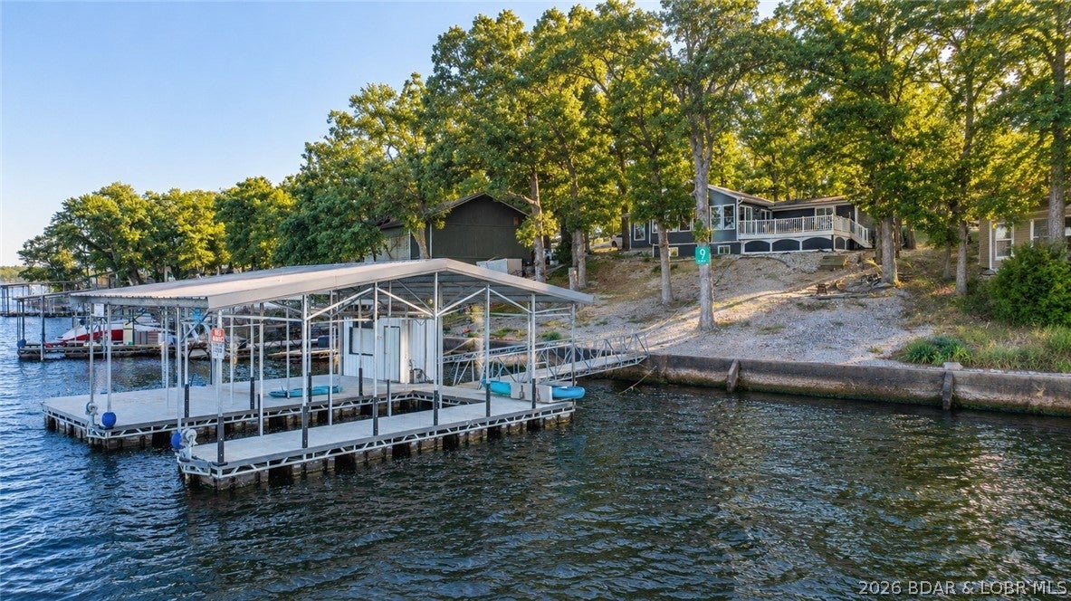 Rare single-level lakefront living with panoramic views at the 9 mile marker! This 3 bedroom, 2 bathroom home offers nearly 1,600 SqFt, 91 feet of lakefront, and was completely renovated in 2019. The open interior features vaulted ceilings, granite kitchen countertops, and an abundance of windows showcasing the lake from throughout the home. Two of the three bedrooms also feature lake views, making the water the focal point from nearly every angle. Outside, composite decking and multiple entertainment areas provide plenty of room to relax and take in the panoramic setting. The newer concrete dock features a 12x36 slip, large swim platform, and a dock shed complete with a bar, creating an ideal setup for days on the water and entertaining guests. With everything conveniently located on one level, this property offers the rare combination of true lakefront living without navigating multiple floors. Nightly rentals are allowed, providing the flexibility to enjoy it as your personal Lake getaway, full-time residence, or income-producing investment.