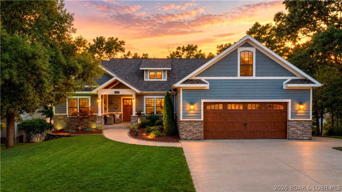 Stunning custom-built home designed for full-time living or the perfect lake getaway with lake access. Thoughtfully designed with a flat driveway, level front yard, and three main-level bedrooms, this home offers comfort for all ages. The open-concept kitchen & living room are bright & inviting, creating ideal space to gather while enjoying peaceful outdoor views. A spacious bonus room above the garage with a half bath is perfect as a 6th bedroom, home office, guest room, gym, playroom, or hobby space. Enjoy two living areas, a screened porch with a two-sided fireplace, & a relaxing primary suite featuring a spa-like bath with a walk-in shower, soaking tub, & walk-in closet. An oversized laundry room & a deep, spacious lower-level utility garage provides exceptional storage & flexibility. Community dock access via stairs or golf cart makes lake restaurants, marinas, & entertainment only minutes away by boat from the 12MM. Boat slip options available. Brand-new roof installed May 2026. Located on a quiet cul-de-sac with a community pool, seasonal lake views, quality construction, & a welcoming year-round neighborhood, 135 Windjammer truly offers the best of Lake of the Ozarks living