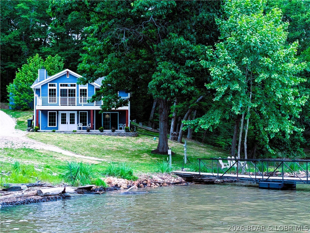 OPEN SATURDAY AND SUNDAY JUNE 27-28 1-4 PM. For this beautiful lakefront home feels like brand new. Recently rebuilt top to bottom delivers quality craftsmanship inside & out. All the work has been done & ready to move in. Step inside the well designed floor plan for lakeviews & high end details. Open main level living room spans the entire front of home with wall of windows & fireplace . Spacious kitchen, upgraded cabinetry, granite counters, bar, SS appliances & laundry room. Staircase opens up to vaulted ceiling familyroom,  Main bedroom suite, 2nd  bedroom & half bath. Exterior door to back yard deck. One nonconforming BR for guest or office. Sun filtering through the trees makes it easy to find wood for the fireplace. Green grass &  landscaping  gives an easy stroll, no stairs to 2 well boat dock.Level lakefront &  sandy beach is hard to beat & find at the lake making this property dog & kid friendly. 100 ft  +/-  at waters edge just over a half acre & water depth for all the seasons. 20 x 18 metal garage/shop electric & shed for storage. End of road with parking for family & friends privacy & space in a cove protected with main channel view. Home faces east to enjoy sunrise.