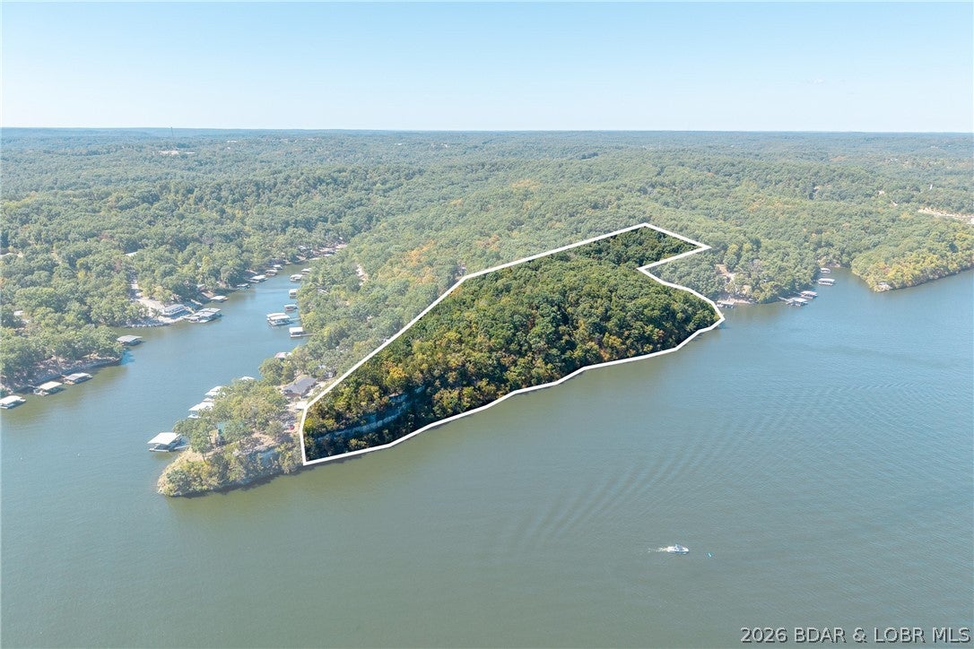 Some properties are simply irreplaceable and this is one of them. Offered as two parcels together, spanning 16 pristine acres along the Osage Arm at the 34 mile marker, this rare lakefront offering boasts an estimated 1,675 feet of lake frontage and provides an extraordinary canvas for a private estate unlike anything else on the market. Tons of level land make this parcel ideal to build on, with ample room for multiple homes, each with the potential for amazing lake views and dock ability. Sweeping shoreline, sun-drenched water views, and rolling acreage come together to create a setting of true seclusion and grandeur, just minutes from the conveniences of Camdenton. Dock drawings have already been thoughtfully drafted, offering a head start toward realizing your vision on the water. Whether envisioned as a legacy family estate, a multi-home development, or a signature custom build, this is an exceptional opportunity at the Lake of the Ozarks.