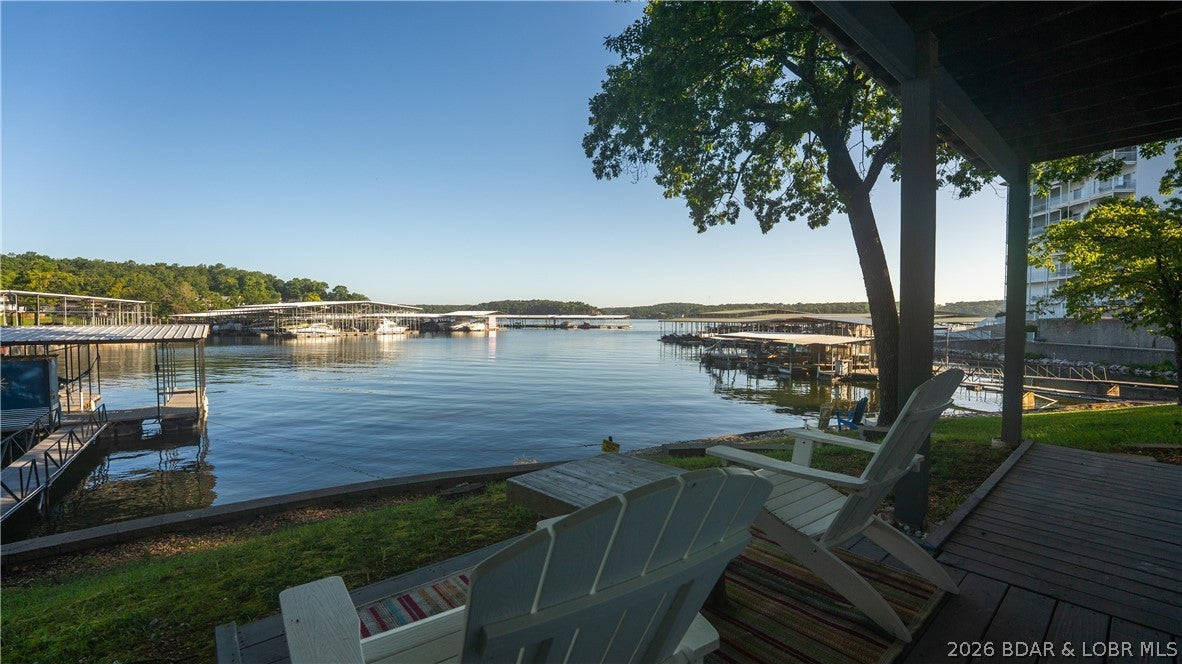 Investment Opportunity Alert! This outstanding nightly rental located in the heart of Osage Beach on the 20 mile marker has several unique features that make it an excellent rental:  the fact that all 4 bedrooms have a private bathroom & shower within each room is the feature that most renters love, the 177' of shoreline & main channel views from the property while still located in a protected cove, over 500 sq. ft. of decks where one can catch an awesome sunset, a 2 well dock with 3 PWC Shore ports, three kayaks, a lily pad, & a swim platform, 8 smart TVs scattered throughout the place & plenty of off-the-street parking.  The walkout basement is now a bunkroom and from there, it's a short walk to the dock or the hammock that is near the bottom deck. There are two washer / dryer hookups on the main level should an owner want to have two stackable sets going at the same time and with the propane fueled tankless water heater, there's always hot water. This property is being sold completely turnkey & "As Is" & the possibilities with this property are endless. Rental history is available to view and there's already 28 nights booked for the summer of 2027.