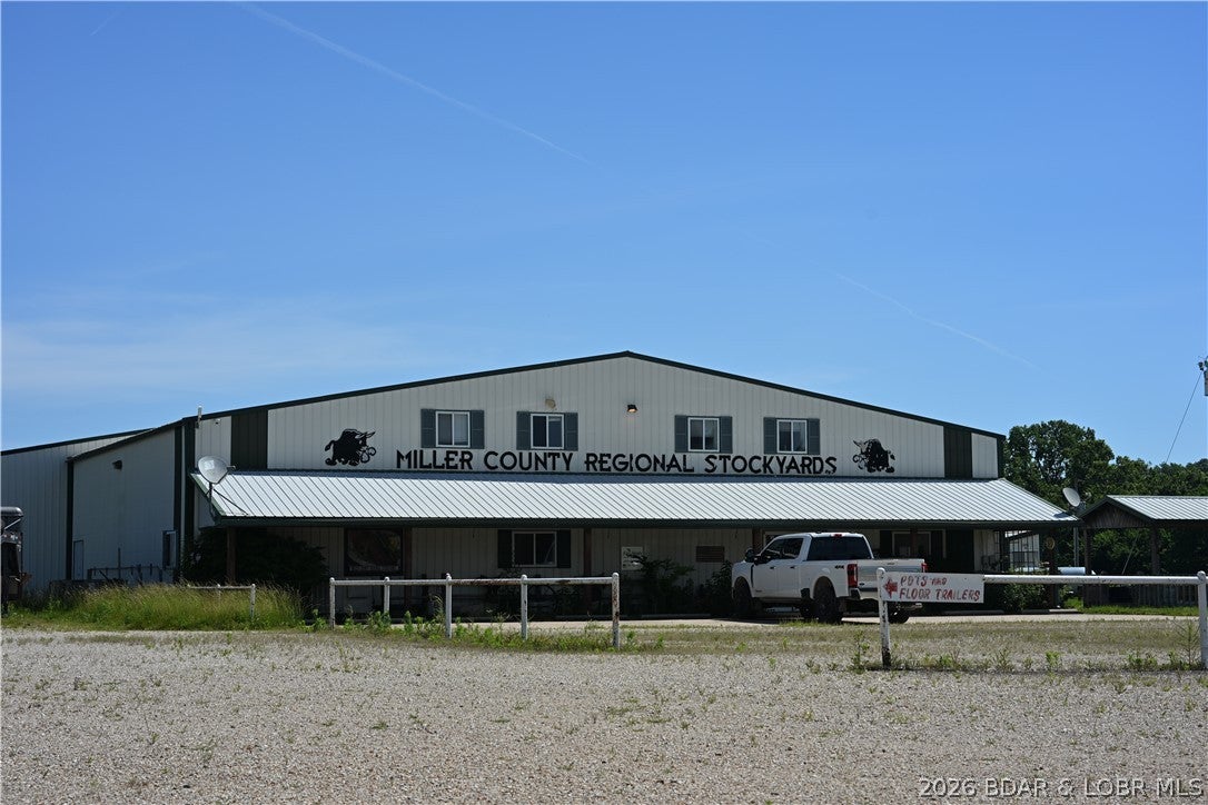 This exceptional 69± acre commercial property in Eldon, Missouri offers prime Highway 54 frontage, outstanding visibility, and extensive existing infrastructure. Formerly the Miller County Regional Stockyards, the site includes more than 65,000 sq ft of improvements, multiple access points, and ample room for expansion. The main facility features a 52,644± sq ft covered steel structure with sorting pens, a 1,440± sq ft sale arena, café, service counter, and a 2-bedroom apartment ideal for onsite management. Additional structures include a bar and lounge, pole barns, storage, truck scales, and concrete parking. Its strategic location between Jefferson City and Lake of the Ozarks makes it ideal for livestock operations, distribution, equipment sales, warehousing, manufacturing, logistics, or multi-tenant redevelopment. Rarely does a property of this scale with direct highway exposure become available, offering both immediate utility and long-term development potential.