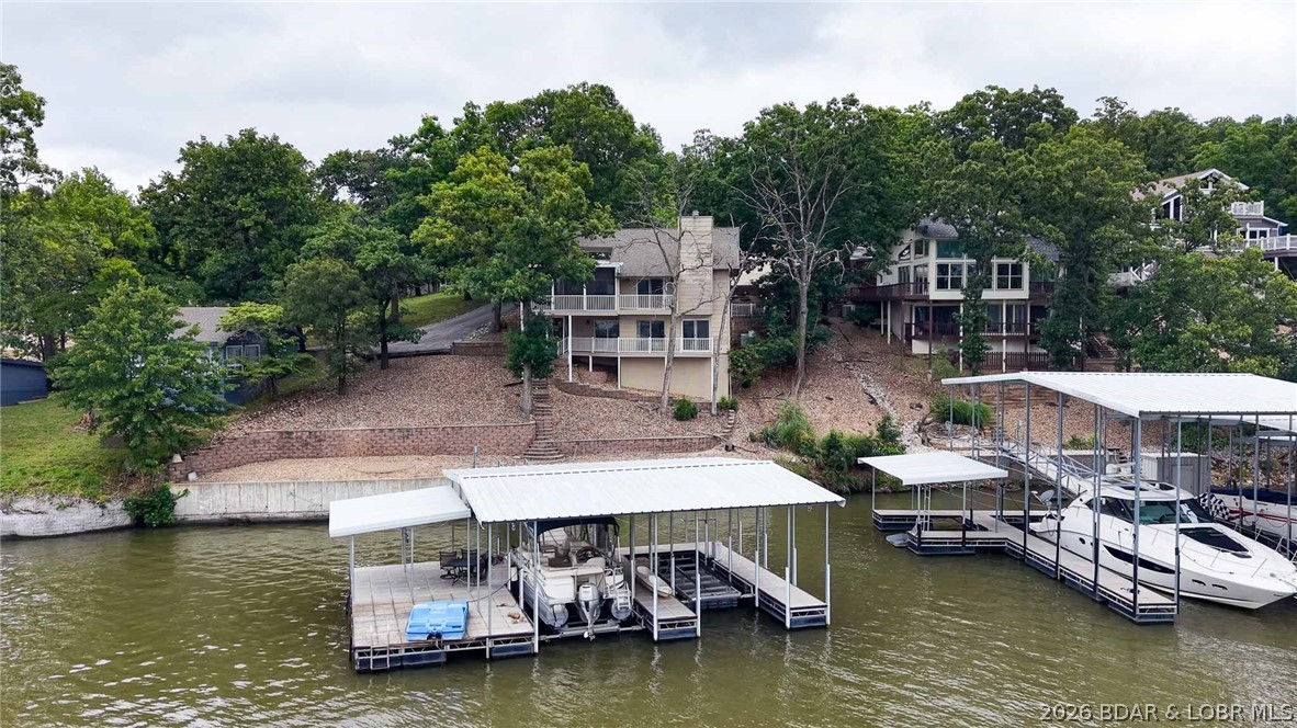RARE opportunities like this are becoming increasingly hard to find in Osage Beach. Offering 102 feet of lakefront, main channel views, deep year-round water, and cove protection for your dock, this 3-bedroom, 2.5-bath home is all about location and potential. Yes, the home is ready for updating, but that's exactly what makes this such an exciting opportunity to create your own lakefront retreat or investment property in one of the Lake's most desirable areas. Convenient by both land and water, you'll enjoy quick access to shopping, dining, entertainment, and popular waterfront destinations. Whether you choose to renovate, rent, or build equity over time, properties with this combination of location, view, protected dock, and price point are exceptionally rare. If you've been waiting for an affordable entry into one of Osage Beach's premier lakefront locations, this is your chance. Opportunities under $800,000 with these features simply don't come along often. The value here is in the irreplaceable setting—buy the location today and update at your own pace tomorrow. Investors, second-home buyers and those seeking lake home take notice before this opportunity is gone.