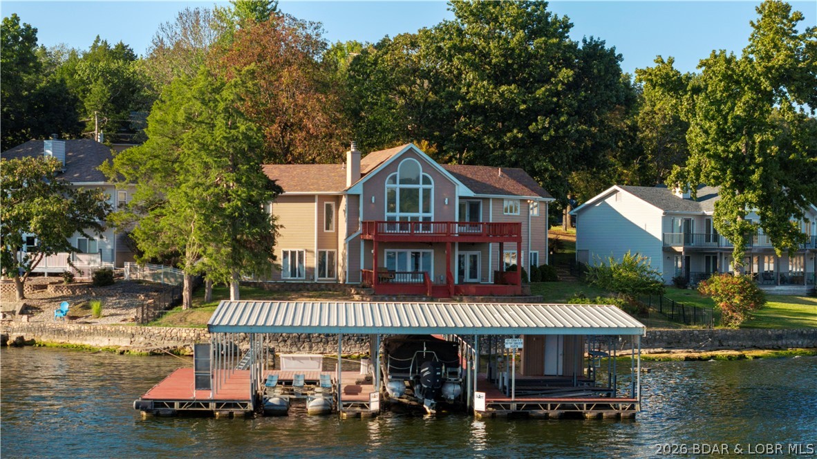 609 Point Charles Rd in Sunrise Beach offers luxury lakefront living with 3,700 sq ft, main-level living, and breathtaking views at the 31 MM. This 3-bedroom, 2.5-bath retreat features vaulted ceilings, an open floorplan, 2 gas fireplaces, custom cabinetry, wet bar, and a spacious lower-level great room with pool table included. Also has an office. Enjoy upper and lower decks overlooking 100 ft of shoreline, a fenced lakeside yard, seawall, and an impressive 3-well covered dock with 12x40 and 12x28 slips, 4 PWC spaces, hoists, and swim platform. Updates include a 2025 furnace and garage door system, 2023 water heater, and 3-year-old roof. Attached 2-car garage, plus the lot across the street is included, providing room to build another garage or shop.