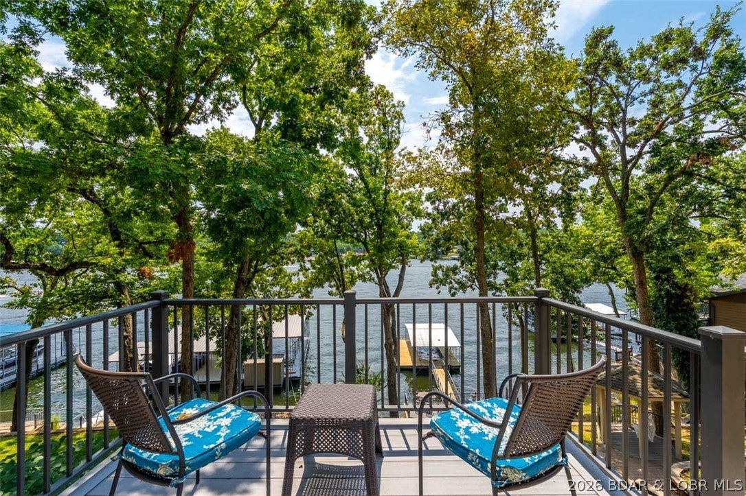Located in one of the most desirable coves at the Lake of the Ozarks, this exceptional waterfront home on the Osage 8 MM offers the perfect blend of breathtaking main channel views and the calm, protected water ideal for tubing, water skiing, and wake surfing.
With 90 feet of deep water shoreline, the property features a one well Ozark Barge dock, providing easy access for all your boating adventures. Relax by the water in the charming lakeside gazebo or entertain family and friends on the spacious maintenance free deck while taking in the spectacular lake views. Inside, you'll find 5 bedrooms and 4 bathrooms, offering plenty of room for family & guests. The home features custom kitchen cabinetry & a layout that's perfect for gathering after a day on the water. Conveniently located near many popular waterfront restaurants. Whether you're looking for a full time residence, a weekend retreat, or an investment opportunity, this home has it all. With its prime location, outstanding water depth. 0ne of the lake's best coves don't come along often!