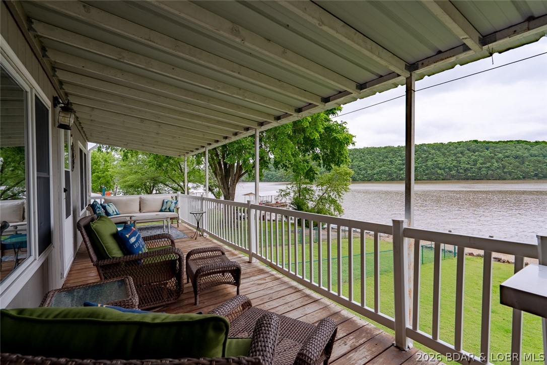 Price Reduced!  Experience the ultimate Lake of the Ozarks lifestyle with this turnkey 4-bedroom, 2.5-bath lakefront retreat at the 66 MM! Boasting 150 ft gentle shoreline & breathtaking main channel views, this fully furnished home is ready to start memory making from day one. The spacious lower level features a cozy wood-burning fireplace and walls of windows that bring the lake views inside. The kitchen offers abundant cabinet space, an easy-flow dining area, & beautiful lakefront scenery. The oversized remodeled primary ensuite is designed for comfort with a stunning walk-in shower, double sink vanity, and separate his-and-hers closets. Recent updates include modern Luxury Vinyl Plank flooring throughout the main floor. Outside, enjoy a large yard, a 20x24 two-car garage, and a dock with a 12x30 boat slip. A whole house Generac generator gives you peace of mind for the unexpected. Two additional lots across the road open the door for endless possibilities — build a shop, create extra parking, or design your own lake retreat expansion. To complete this incredible package, a 2008 22’ Party Barge pontoon in included. This is the total turnkey lake property you’ve been waiting for!