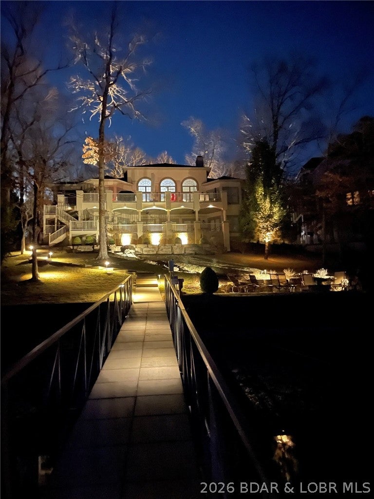 This home is the perfect combination of architectural elegance and comfortable lake living in the most exclusive Porta Cima address!! Cove protection, mature landscaping including winding waterfall and large fire pit, large flat drive, and open floor plan with tons of covered decks allow you to entertain like a celebrity. The kitchen flows into a light and bright dining area and living room with wood floors, stacked stone fireplace and bookcase accents. The luxurious main level suite offers tons of privacy with spa-like bath including double vanities, tub, walk-in shower and large closet. Guests will love the lower level with family room including custom bar and large lakeside covered decks. Lake living is all about outdoor fun--tons of deck space, large lakeside firepit for those late night s'mores and your own private concrete dock give you tons of options! All of this is situated in an exclusive cove--great for hanging out on the swim platform with custom bar overlooking the beautiful cove setting and fabulous sunsets! This is the perfect lake retreat!