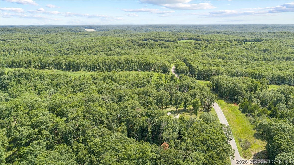 58+/- wooded acres in Morgan County, Missouri, offering an excellent opportunity for hunting, recreation, or a private getaway in a scenic location just north of the Osage River. The property features gently rolling, primarily wooded terrain with paved frontage along a state highway T, providing convenient year-round access. The property is equipped with electric service and a well, along with a shed and an additional outbuilding, providing useful infrastructure for recreational use, storage, or future improvements. The combination of timber, rolling terrain, and a location between Truman Lake and Lake of the Ozarks creates excellent potential for hunting, wildlife viewing, hiking, camping, and other outdoor activities. Located just north of the Osage River and within easy reach of both Truman Lake and Lake of the Ozarks, this property offers convenient access to some of central Missouri's premier outdoor recreation. Whether you're looking for a hunting tract, weekend retreat, recreational property, or a place to establish a private rural getaway, this 58+/- acre tract is worth a look. The property is located within the Morgan County R-1 School District.